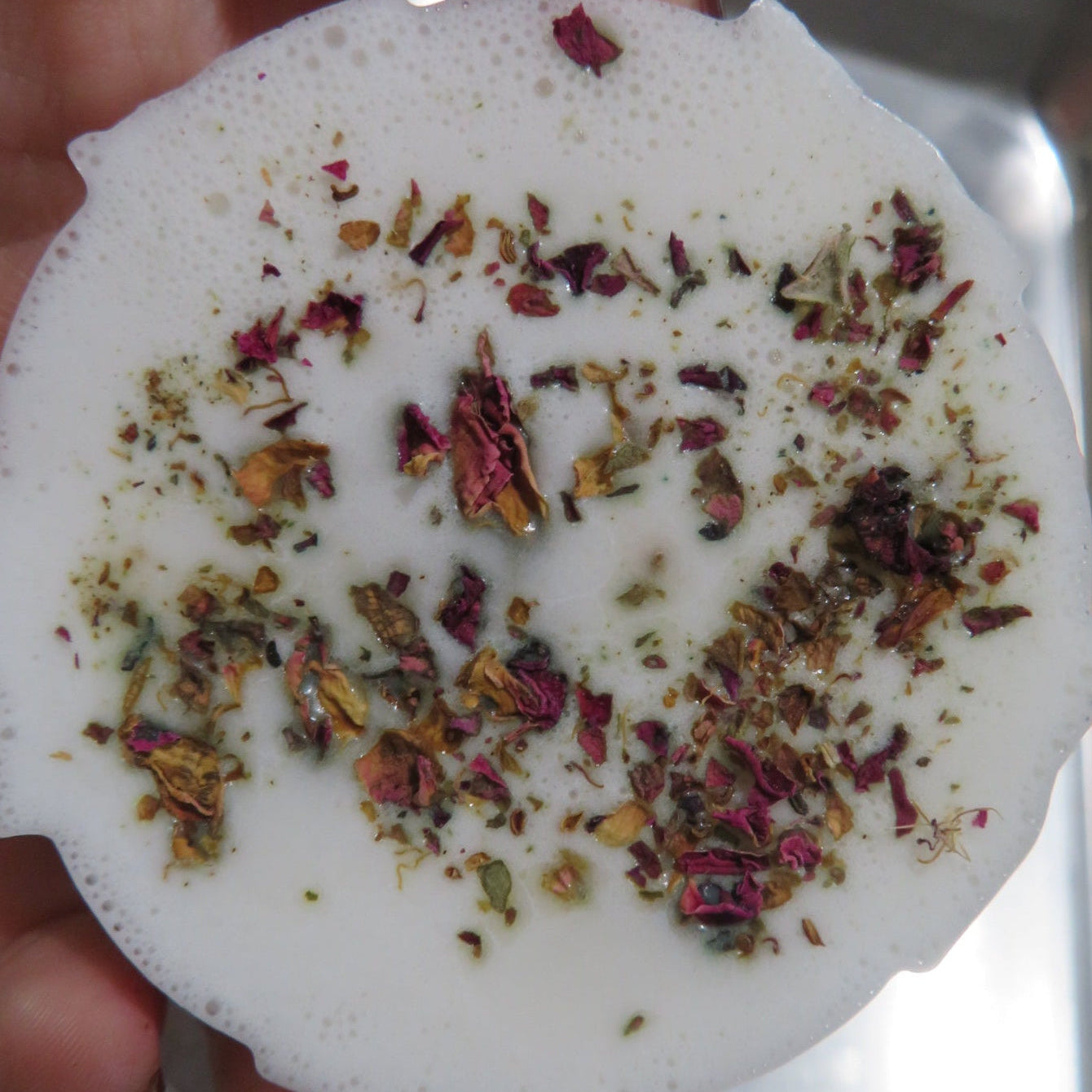 White round soap with dried flowers on a white background